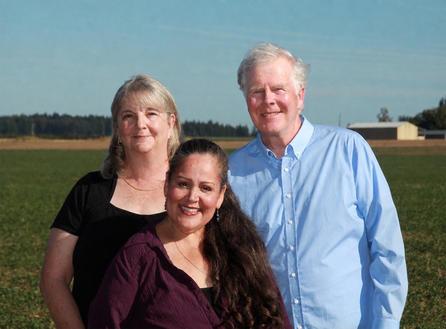 Anna Warrington, Melody Axe and Don Weber standing together in a field outside North Plains, Oregon.